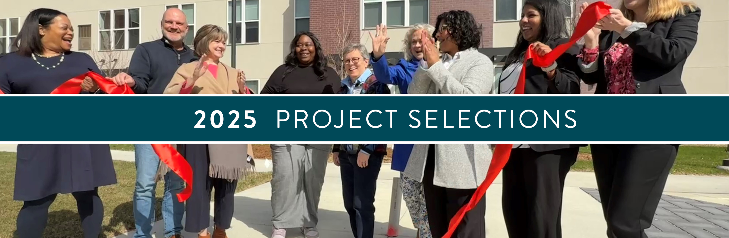 A group of people celebrate a ribbon cutting outside a new rental development