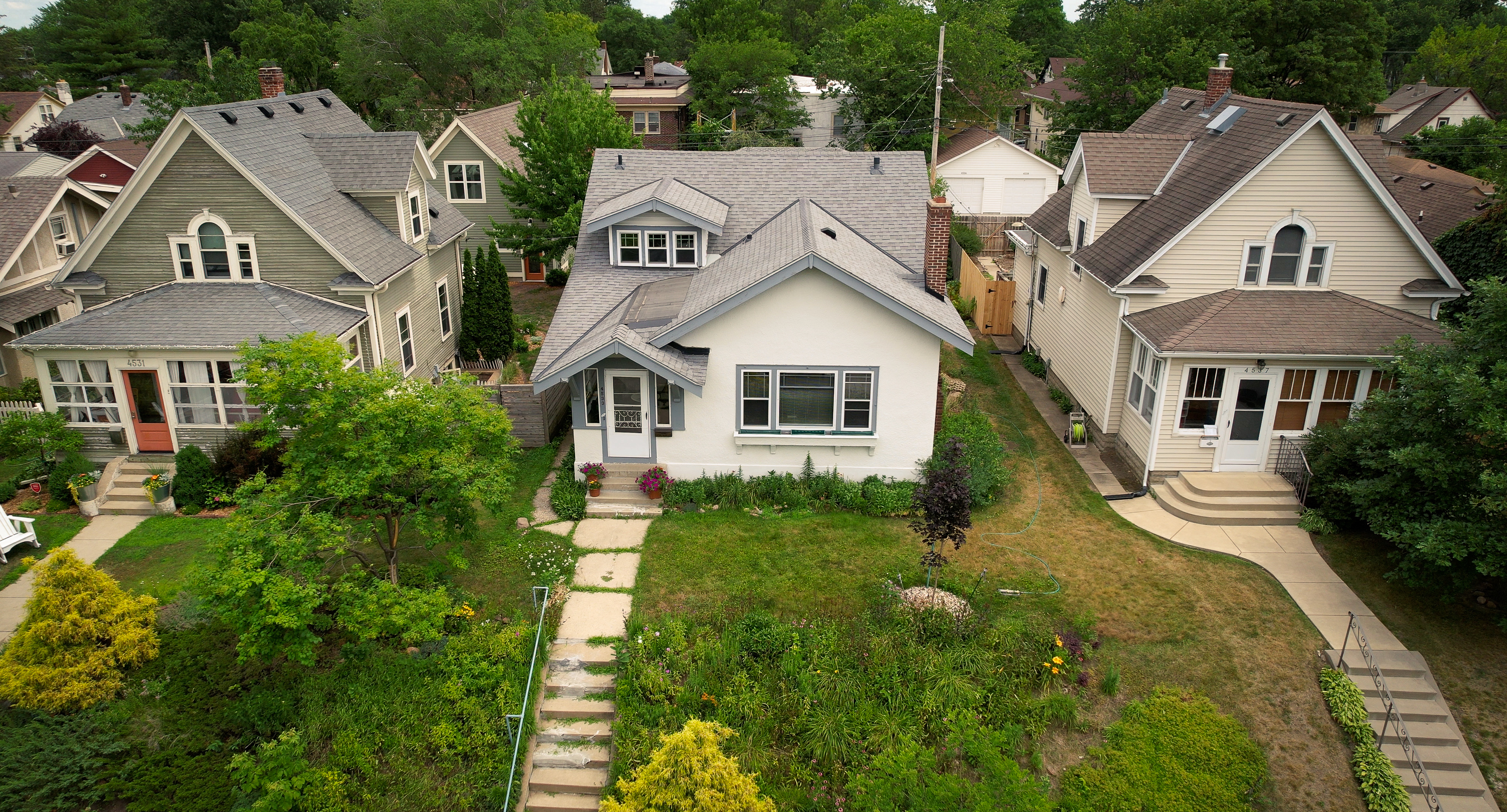 Aerial view of three single family homes.
