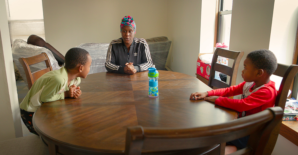 Woman_and_two_children_sitting_at_table
